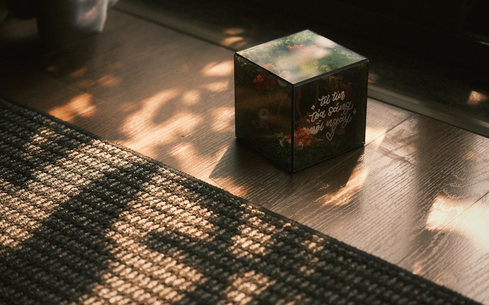 a stack of hardbacks on a wooden floor, warm light
